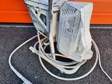 a small machine that is sitting on the ground next to a wall