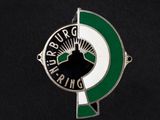un gros plan d'un insigne vert et blanc sur une surface noire