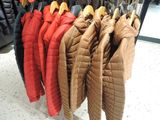 many coats hanging on a rack in a store