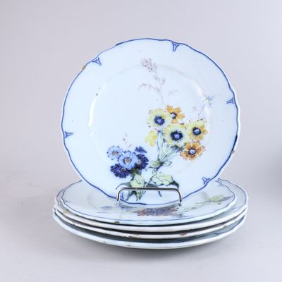 quatre assiettes empilées les unes sur les autres, ornées de fleurs