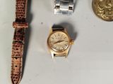 a gold watch and a silver watch on a table