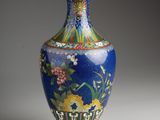 un vase bleu bordé d'or sur un fond blanc