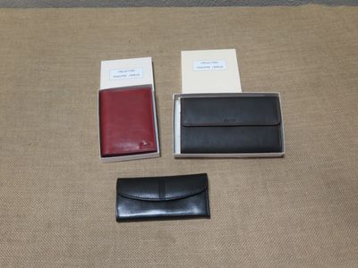 deux portefeuilles noirs et rouges posés sur une table
