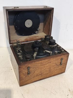 un tourne-disque à l'ancienne dans un coffret en bois, posé sur une surface blanche