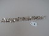 a close up of a silver bracelet with a tag on it