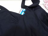 the back of a black sports bra top laying on top of a bed