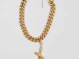 un collier à chaîne en or auquel est suspendu un pendentif en forme de croix