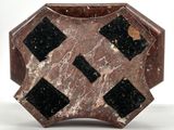 a brown and black vase with black squares on it