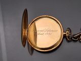 a gold pocket watch with a chain attached to it