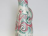 a white vase with a pink and green design on it