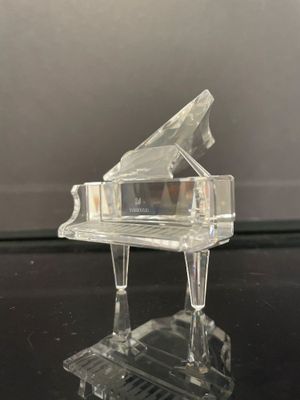 un piano en verre transparent posé sur une table noire