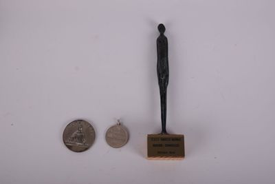 une petite statue représentant un homme debout à côté d'un penny