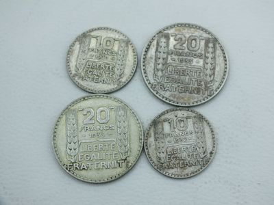 quatre pièces d'argent empilées les unes sur les autres sur une surface blanche