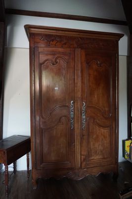 une grande armoire en bois dans le coin d'une pièce