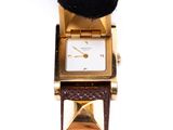 an image of a close up of a wrist watch with a hat on top of it