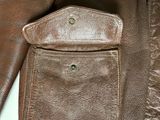 a close up of a brown leather jacket with a pocket