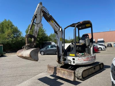 a small excavator that is sitting in a parking lot