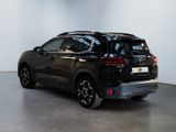 the rear end of a black suv parked in a white room