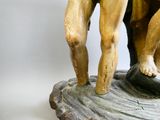 une statue représentant un homme et une femme debout sur un rocher
