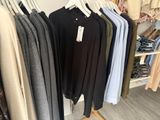 clothes hanging on a rack in a clothing store with a price tag