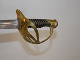 a close up of a sword on a white surface