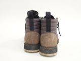 the back of a pair of brown and black boots on a white surface
