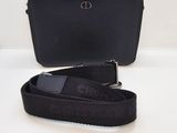 un sac à main noir muni d'une bandoulière et sur lequel est posé un téléphone portable