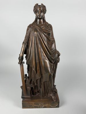 a bronze statue of a woman holding a sword and shield