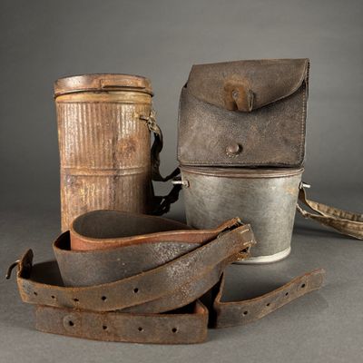 two old metal buckets and a leather case on a table