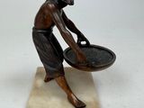 statue of a man holding a bowl of water on a marble base