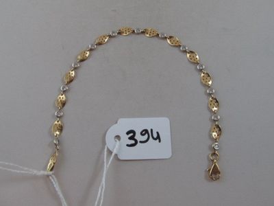 un bracelet en or et en argent sur lequel est accrochée une étiquette de prix