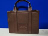 a brown leather handbag sitting on top of a white table