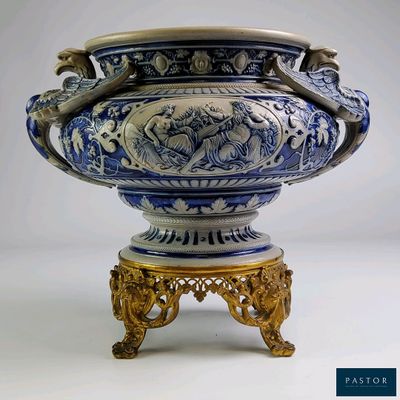 un grand vase bleu et blanc posé sur un socle doré