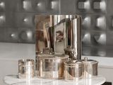 a marble counter top with silver pots and a mirror