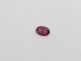 a close up of a pink stone on a white surface