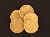 a close up of a pile of gold coins on a black background