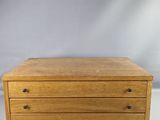 une petite boîte en bois surmontée de trois tiroirs
