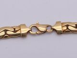 a gold bracelet with a heart design on it