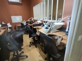 many desks and chairs in a room with a large mirror
