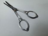 two pairs of scissors sitting on a white surface