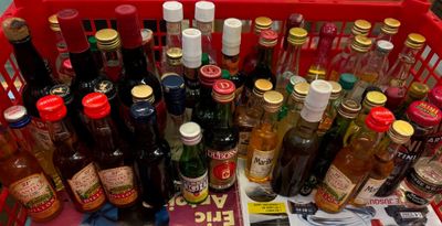 many bottles of liquor in a red basket on a table