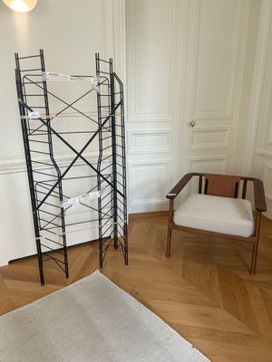 a chair in the corner of a room next to a book shelf