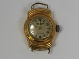 a gold wrist watch with a white face on a white surface