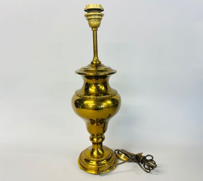 an antique brass table lamp with a cord attached to it