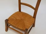 a small wooden chair with a woven seat on a white background