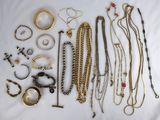 many different types of necklaces and bracelets laid out on a bed