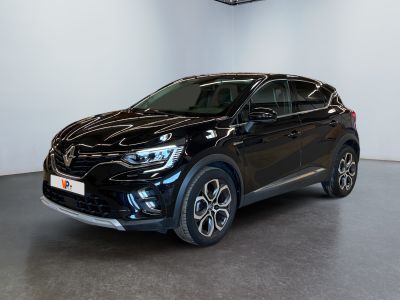 Une voiture noire est garée dans une grande pièce aux murs blancs.