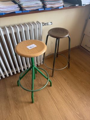 deux tabourets placés devant un radiateur dans une pièce