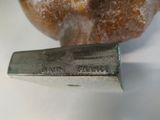 a metal knife sitting next to a doughnut on a table