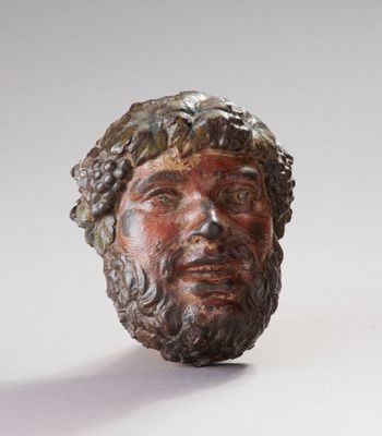 sculpture représentant la tête d'un homme barbu aux cheveux bouclés